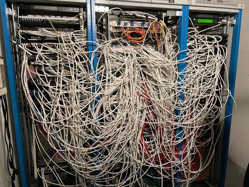 Baie de brassage avec câbles emmêlés avant intervention de remise en ordre